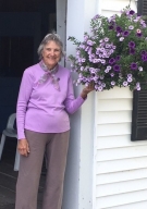 Elizabeth Paine Sawyer in a purple sweater next to purple flowers